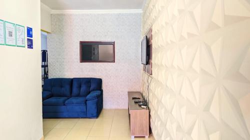 Un sofá azul en una habitación con una pared. en Casa com piscina no centro de Maragogi pertinho da praia!, en Maragogi