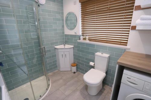 een badkamer met een toilet en een glazen douche bij Tweedbank in Galashiels