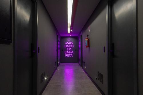 a hallway with purple lights and a sign on the wall at TOLIVE One Housi Recife by Carpediem in Recife