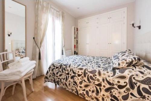 a bedroom with a bed and a table and a window at Luminoso Apartamento en Lavapiés-Tirso de Molina in Madrid