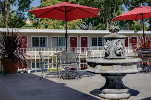 a fountain with a red umbrella in front of a building at Campus Inn & Suites Eugene Downtown in Eugene