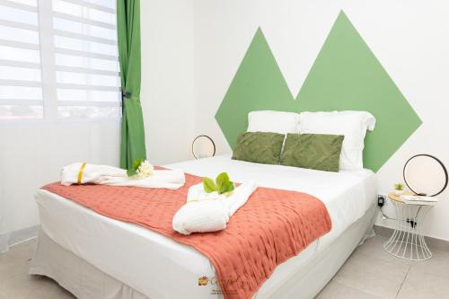 - une chambre avec un lit et des serviettes dans l'établissement La Géométrie à 5 minutes du centre-ville et de la plage, à Cayenne