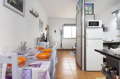 a kitchen with a table and a white refrigerator at EDEN RENTALS Atogo Cozy Apartment in Granadilla de Abona