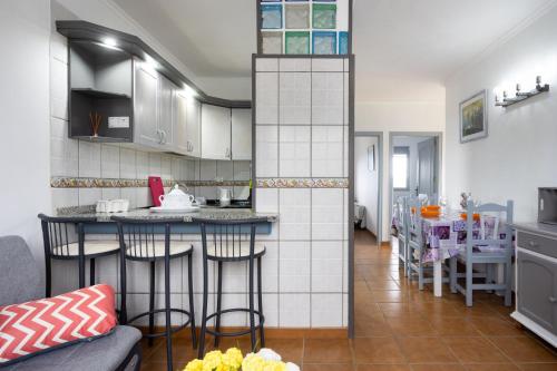 a kitchen with a bar in the middle of a room at EDEN RENTALS Atogo Cozy Apartment in Granadilla de Abona