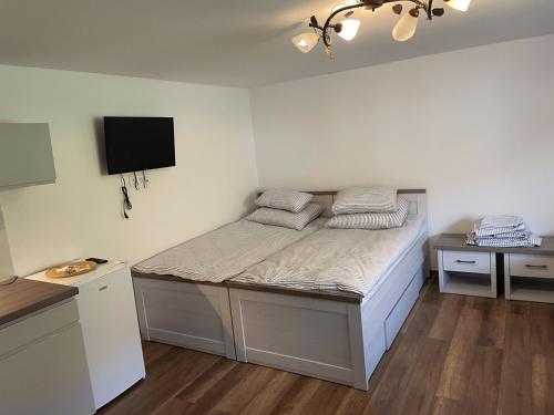 a small bedroom with a bed and a tv at U Rybaka in Braniewo