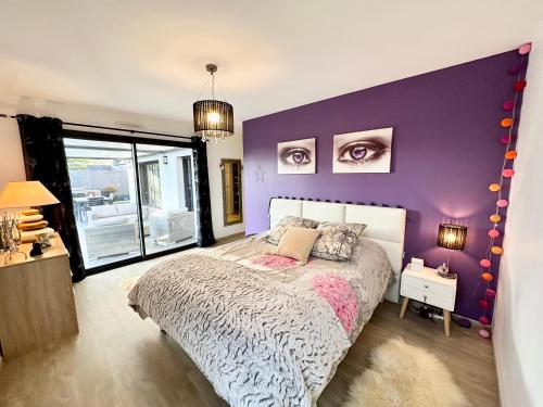 プロムールにあるMaison d’architecte contemporaine – À 5 min des plagesの紫の壁のベッドルーム1室、ベッド1台が備わります。
