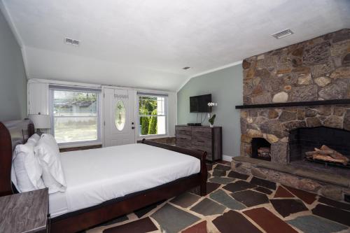 a bedroom with a bed and a stone fireplace at Hamptons Vacation Inn in Hampton Bays