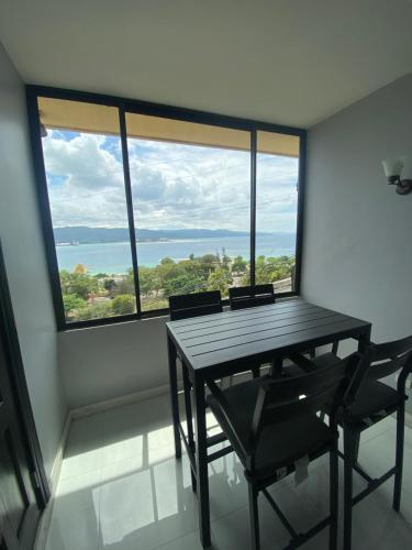 a table and chairs in a room with a large window at K&S SEAVIEW luxury apartment in Montego Bay