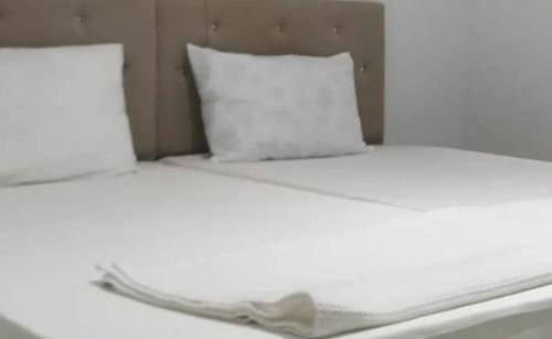 uma cama com lençóis brancos e uma almofada em zirve apart em Acıpayam