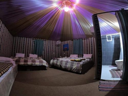 a room with two beds and a purple ceiling at Tareqzwy wadi rum in Wadi Rum
