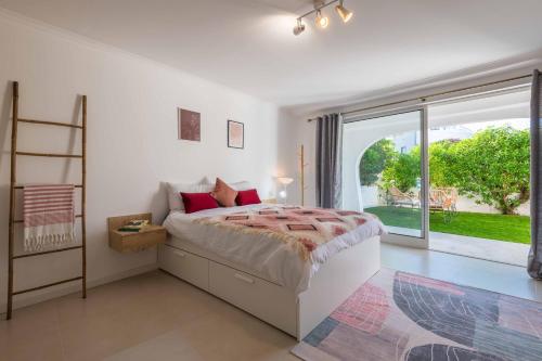 a bedroom with a bed and a large window at Lemon House in Albufeira