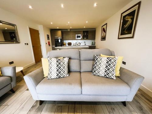 a living room with a couch and a kitchen at The Beach Retreat in Sandown