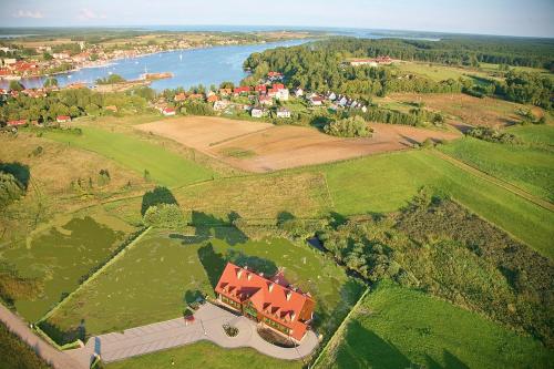 an aerial view of a house in a field with a river at Mazurska Chata jezioro i aquapark 6 min centrum i promenada 12 min in Mikołajki