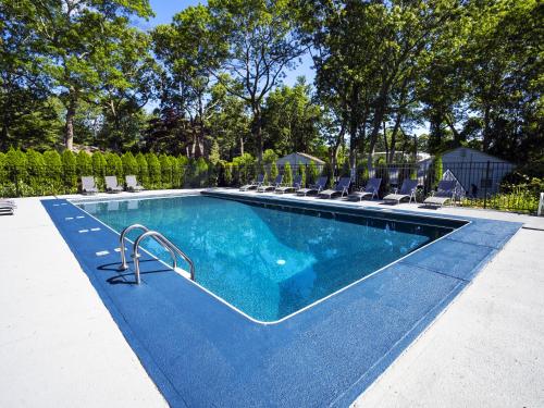 a large swimming pool with lounge chairs at Hamptons Vacation Inn in Hampton Bays