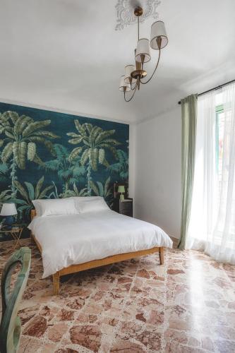 a bedroom with a large bed with a painting on the wall at A Calata Rooms in Noto