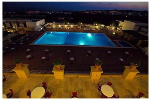 una piscina con tavoli e sedie di fronte di Messapia Hotel & Resort a Marina di Leuca