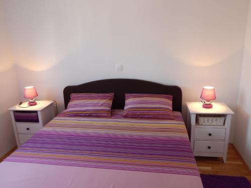 ein Schlafzimmer mit einem Bett mit zwei Nachttischen in der Unterkunft Apartments Linda in Trogir