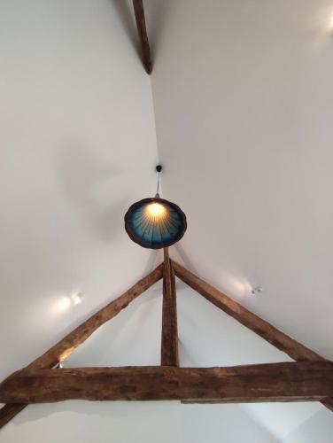 une lumière d'appoint suspendue à un plafond dans une pièce dans l'établissement Le gite du pré dorė, à Bonneville-la-Louvet