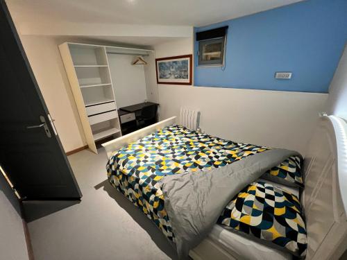 een slaapkamer met een bed en een blauwe muur bij Maison calme pour 6 personnes in Mouilleron-le-Captif