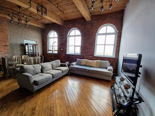 uma grande sala de estar com dois sofás e uma televisão em Detroit Riverwalk Loft em Detroit