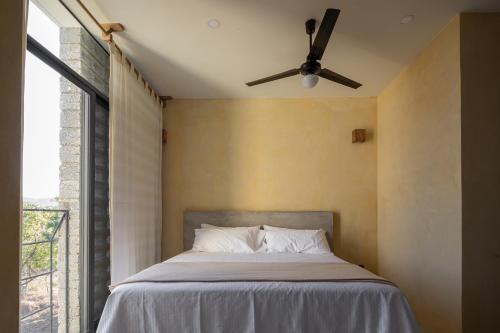 a bedroom with a bed with a ceiling fan at Casa Kame in Puerto Escondido