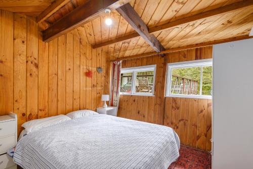 een slaapkamer met een bed in een houten kamer bij Holiday Chalet in Arthurs Pass in Arthur's Pass