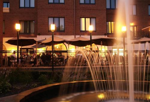 a fountain in front of a building with tables and umbrellas at Saint John's Resort in Plymouth
