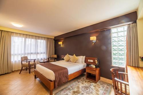 a hotel room with a bed and a large window at Samra Hotel in Nairobi