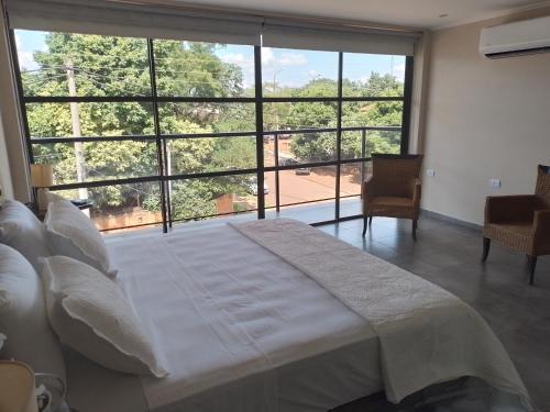 Cama grande en habitación con ventana grande en PICURÙ DUPLEX en Puerto Iguazú