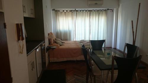 a bedroom with a bed and a table and a window at Temporarios Peatonal in Rosario