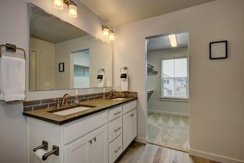 baño con lavabo y espejo grande en Hygee House Brand New Construction near Ford Idaho Center and I-84! Plush and lavish furniture, warm tones to off-set the new stainless appliances, play PingPong in the garage or basketball at the neighborhood park, en Meridian