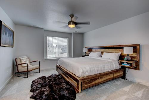 1 dormitorio con 1 cama y ventilador de techo en Hygee House Brand New Construction near Ford Idaho Center and I-84! Plush and lavish furniture, warm tones to off-set the new stainless appliances, play PingPong in the garage or basketball at the neighborhood park en Meridian