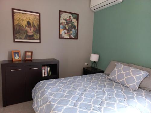 ein Schlafzimmer mit einem Bett und zwei Bildern an der Wand in der Unterkunft Tu depa en Los Mochis in Los Mochis