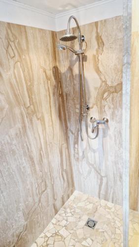 a shower in a bathroom with a stone wall at Gasthof Dorfschenke in Stall