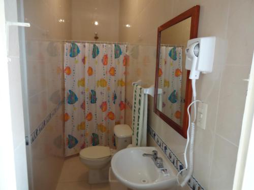 y baño con lavabo, aseo y espejo. en Hotel Figueroa, en San Andrés Tuxtla