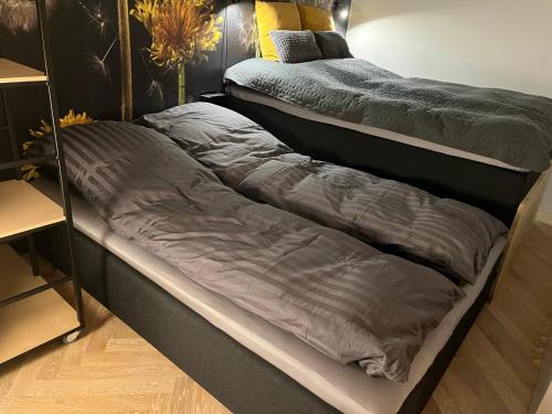 two beds sitting on a bed frame in a room at Apartment directly to seafront of Bassin 7 with big balcony and free parking in Aarhus