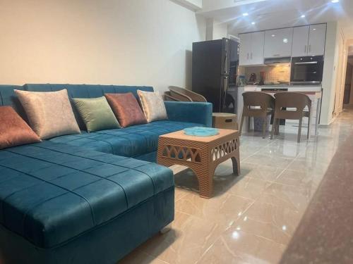 sala de estar con sofá azul y mesa en One bedroom apartment at marina city portghalib en Port Ghalib