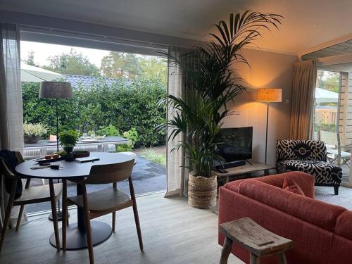 a living room with a red couch and a table at Luxe vakantiehuis “Saalien” in Beekbergen