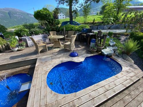 a small pool on a deck with a table and chairs at Minihus med drømmeutsikt til Sunnmørsalpene in Aure