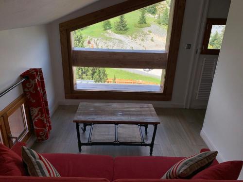 a living room with a table and a large window at Auberge Quintessence in Roubion