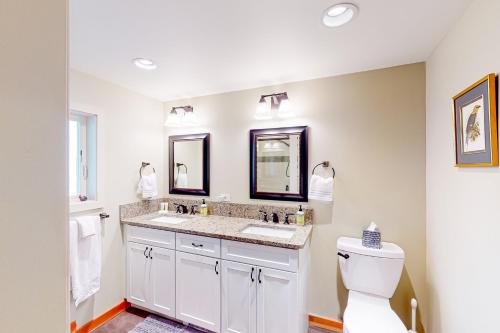 a bathroom with two sinks and a toilet at Gleeson's Bay House in Lopez