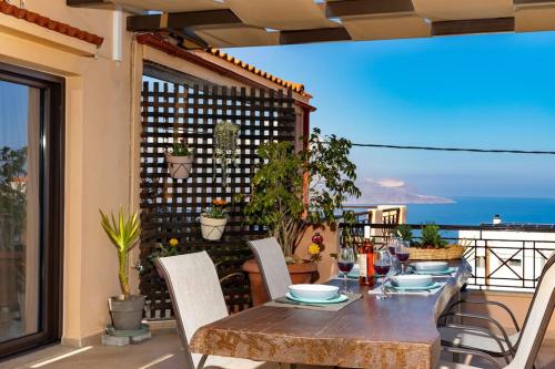 a table and chairs on a patio with a view of the ocean at Celestia House in Kókkinon Khoríon