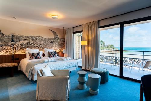 a bedroom with a large bed and a balcony at Hôtel Roz Marine Thalasso Resort in Perros-Guirec