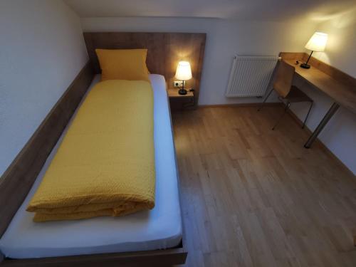 a bed in a small room with two lamps at Haus Viktoria in Mayrhofen