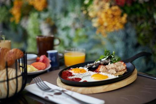 a plate of food with eggs on a table at voco Guadalajara Neruda by IHG in Guadalajara