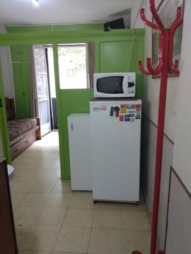 cocina con microondas y nevera en Departamento Sarmiento Zona Aldrey en Mar del Plata