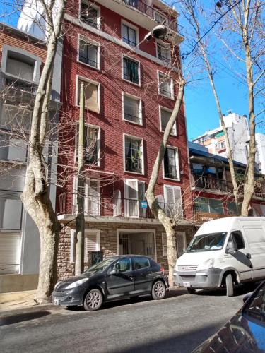 dos coches estacionados frente a un edificio de ladrillo rojo en Departamento Sarmiento Zona Aldrey en Mar del Plata