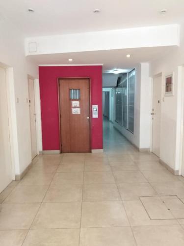 pasillo con puerta roja y suelo de baldosa en Departamento Sarmiento Zona Aldrey en Mar del Plata