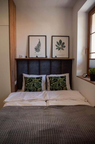 a bed in a bedroom with two pictures on the wall at Place4You in Ostróda