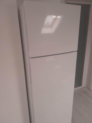 a white refrigerator freezer sitting in a room at Izabella Guest House in Săcele